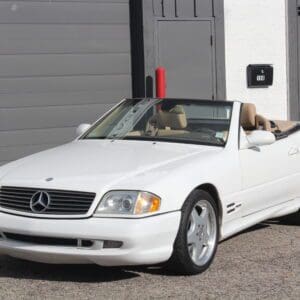 White convertible parked in front of garage.